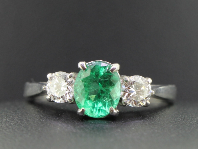 A MESMERISING EMERALD AND DIAMOND TRILOGY 18 CARAT GOLD RING