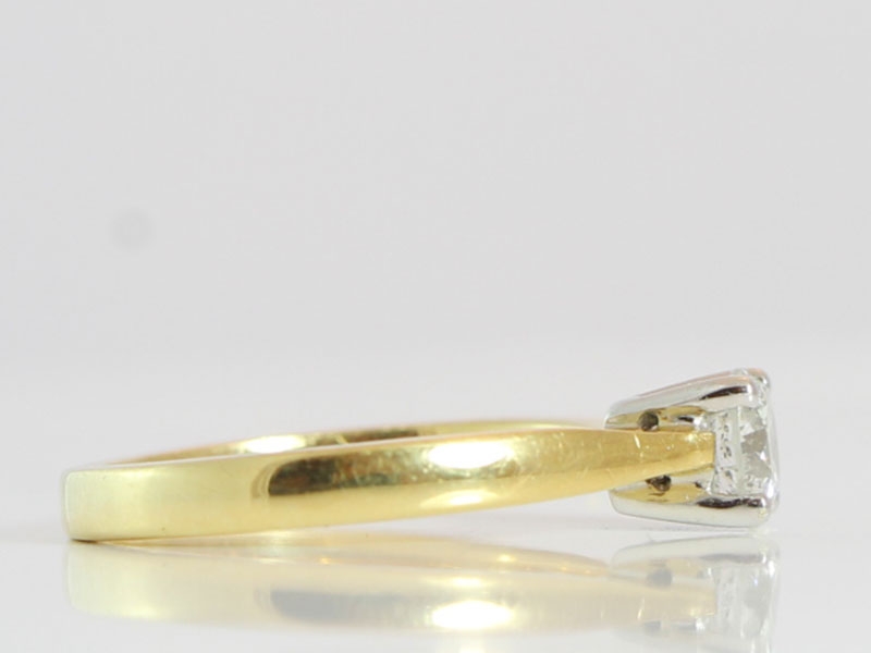 A CLASSIC ROUND BRILLIANT CUT SOLITAIRE DIAMOND RING IN 18 CARAT GOLD