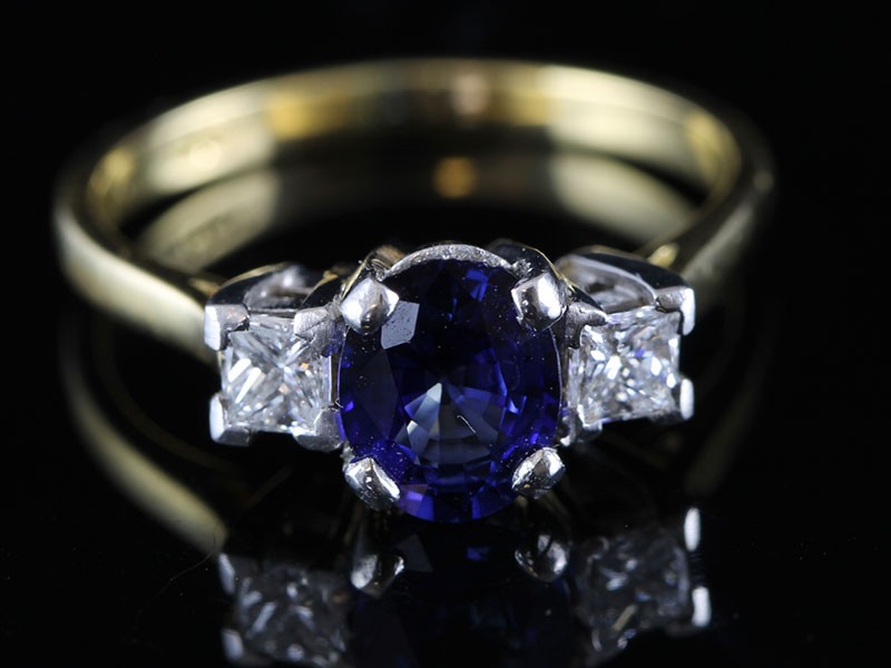 A REGAL SAPPHIRE AND DIAMOND TRILOGY 18 CARAT GOLD RING