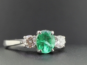 A MESMERISING EMERALD AND DIAMOND TRILOGY 18 CARAT GOLD RING