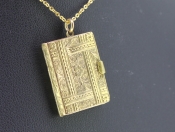 A CHARMING 15 CARAT GOLD BOOK LOCKET 