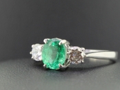 A MESMERISING EMERALD AND DIAMOND TRILOGY 18 CARAT GOLD RING