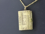 A CHARMING 15 CARAT GOLD BOOK LOCKET 