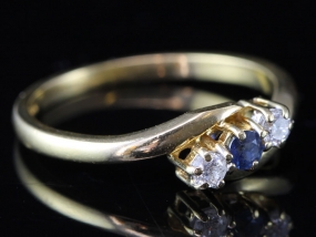 PRETTY SAPPHIRE AND DIAMOND THREE STONE CROSSOVER 18 CARAT GOLD RING