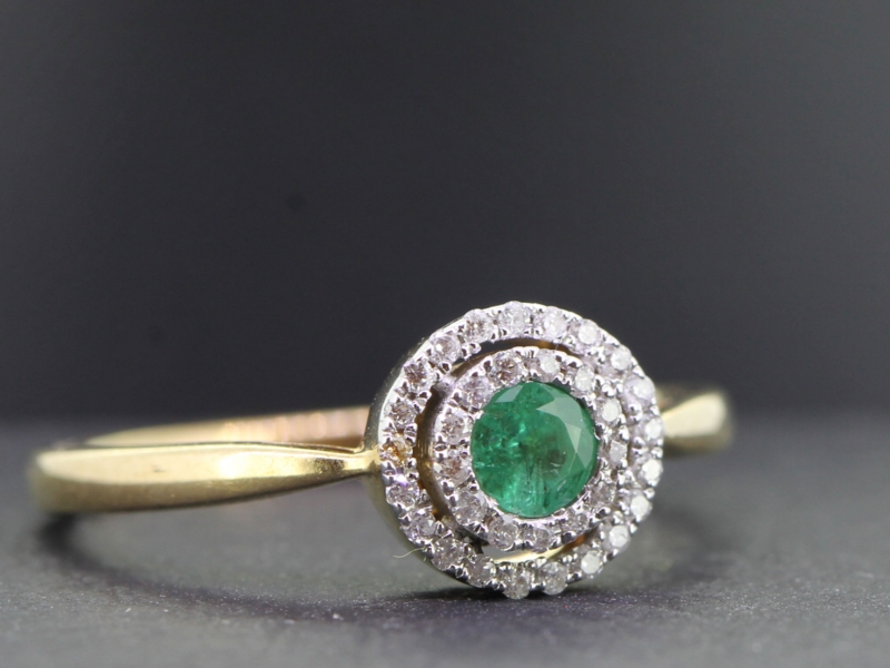 Pretty emerald and double diamond halo 9 carat gold ring