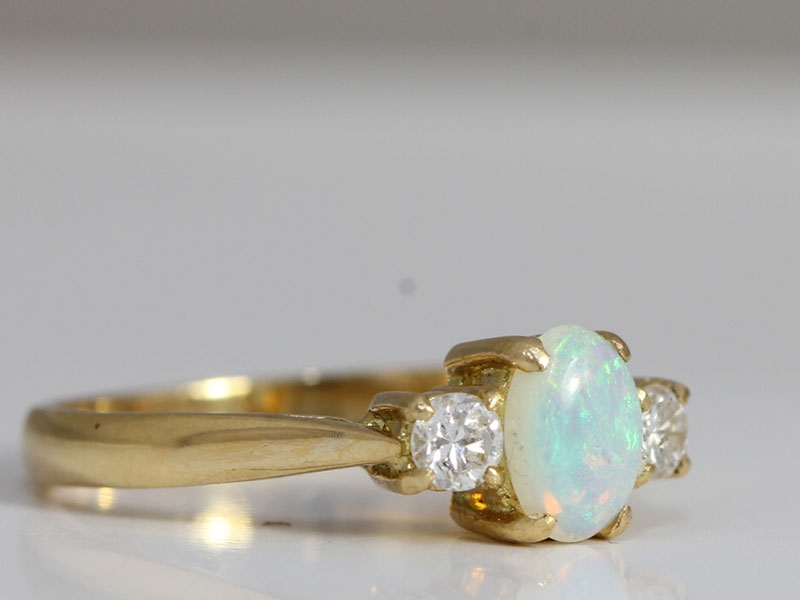 Stylish opal and diamond trilogy 18 carat gold ring