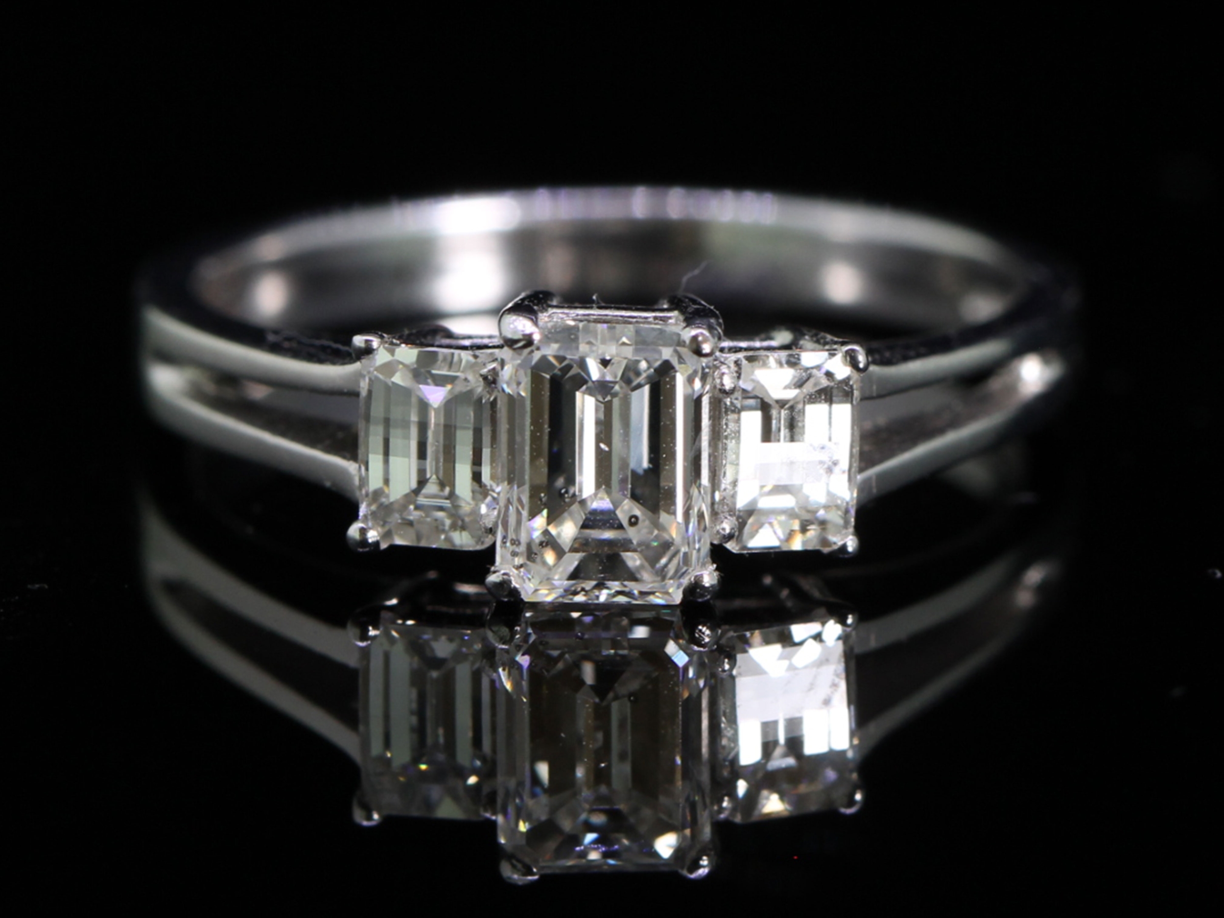 Glamorous emerald cut diamond trilogy platinum ring 