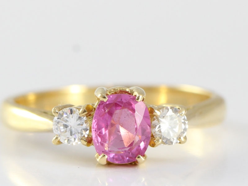 Enchanting pink sapphire and diamond 18 carat gold trilogy ring