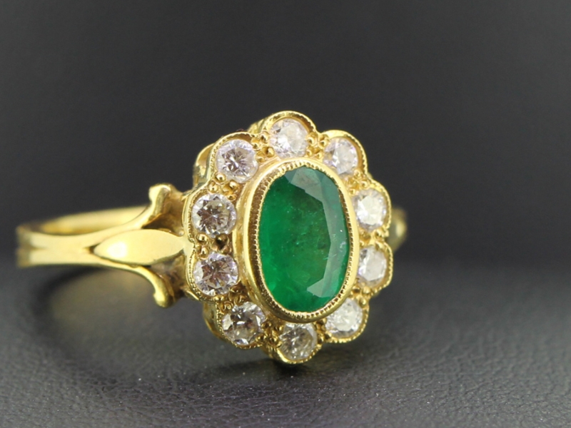 Tantalising columbian emerald and diamond 18 carat gold halo cluster
