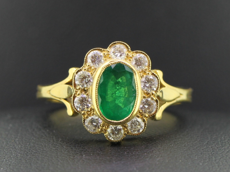 Tantalising columbian emerald and diamond 18 carat gold halo cluster