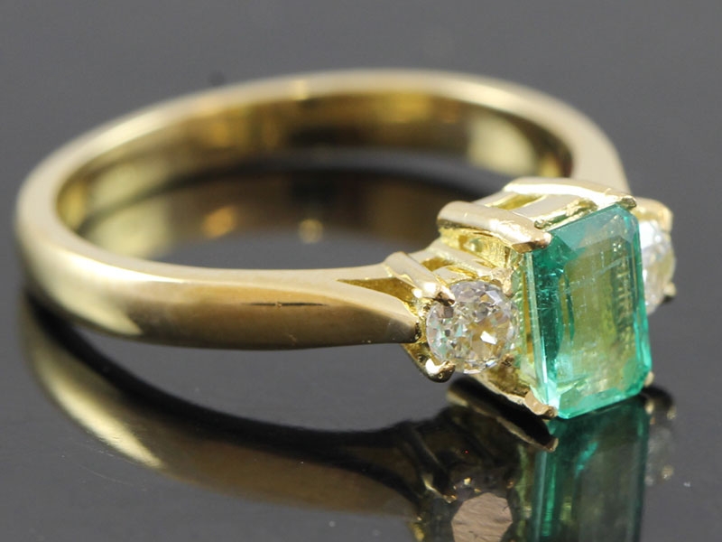 Elegant emerald and diamond trilogy 18 carat gold ring