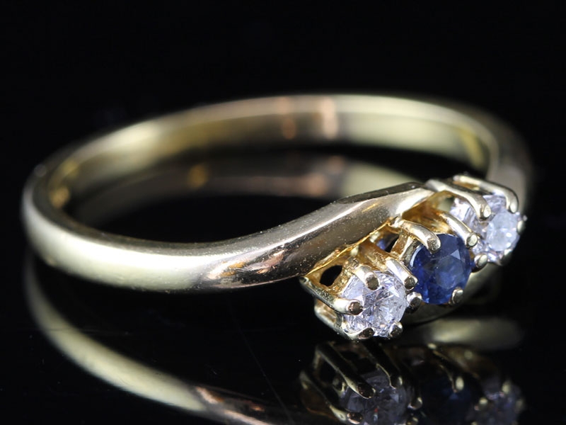 Pretty sapphire and diamond three stone crossover 18 carat gold ring