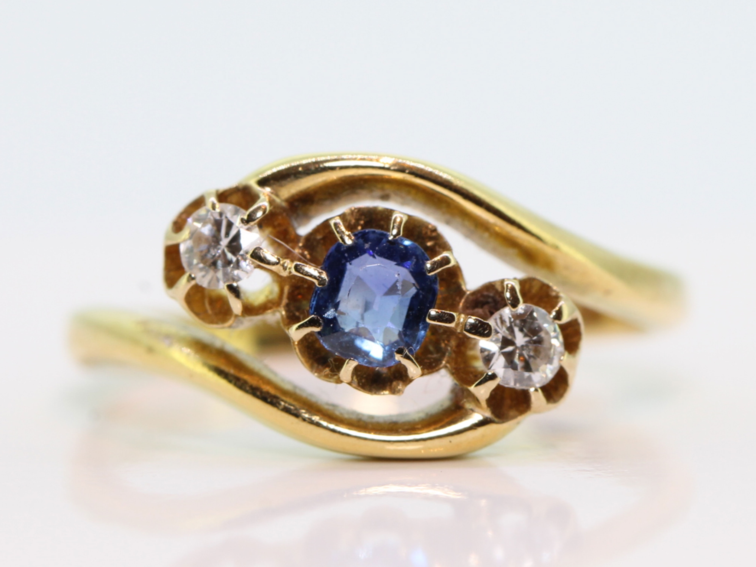 Pretty sapphire and diamond three stone twist ring in 18 carat gold 