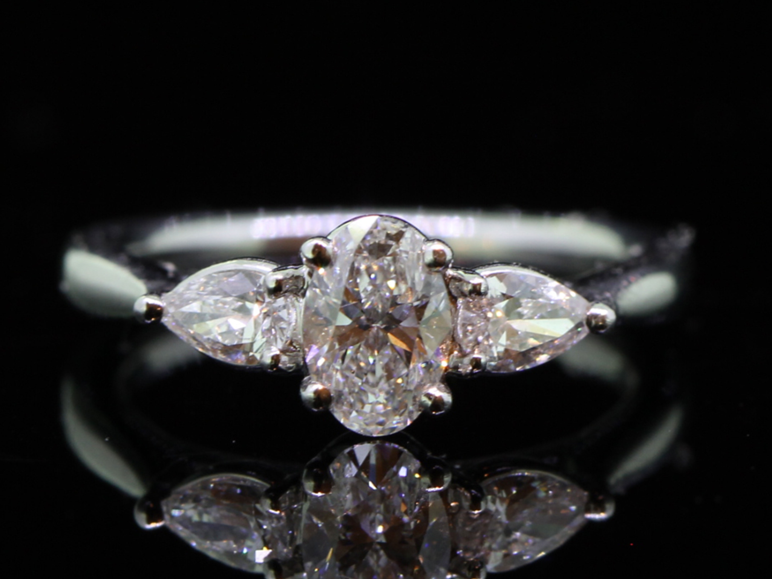 Romantic platinum oval and pear shape diamond trilogy ring 
